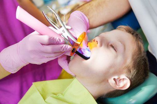Стоматолог лечит малышу периодонтит зуба (фото: www. 32dent.ru)